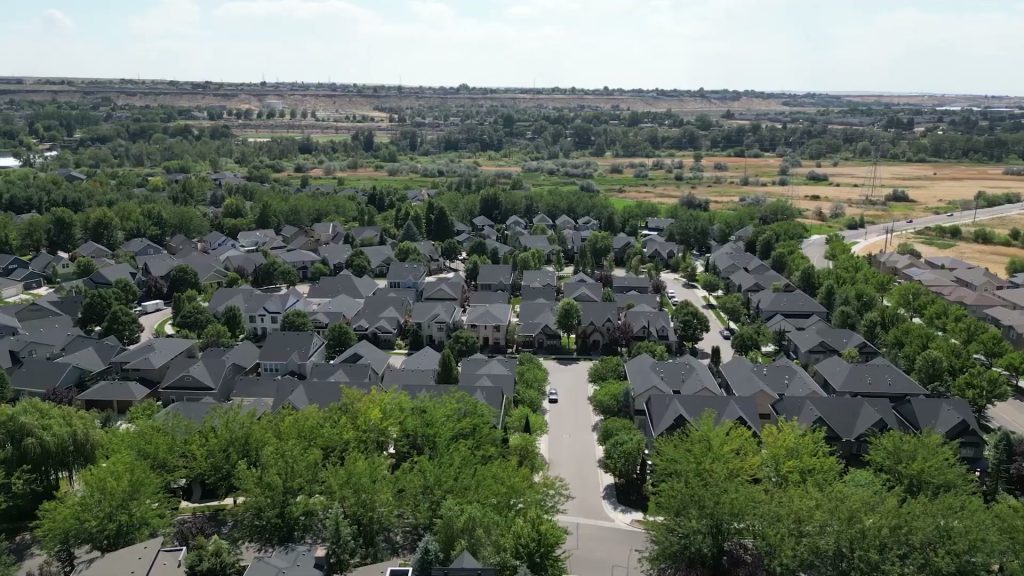 Aerial view of part of the established lower-valley Harris Ranch area in east Boise with homes, mature trees and adjacent open land